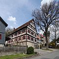 Two-storey half-timbered house with a pitched roof on a high, massive basement