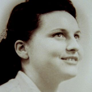 Photo noir et blanc d'un visage de jeune femme brune, souriante, regardant vers le haut