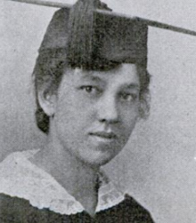 A young fair-skinned Black woman wearing a mortarboard academic cap