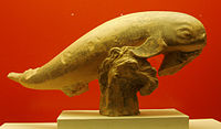 Fragmento de terracota con forma de delfín saltando sobre las olas. Probablemente acrótera de un tesoro. 400 a. C.