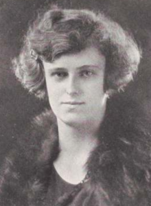 A young white woman with wavy bobbed hair, wearing a dark fur stole