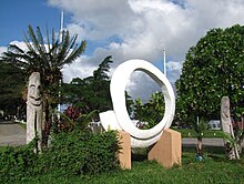 A memorial in Port Vila representing totem poles and a rounded tusk PortVilaMemorialAtParliament.jpg