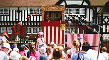 A Punch and Judy show attracts a family audience In Thornton Hough, Merseyside, England Punch and Judy Thornton Hough.jpg