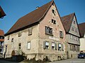 altes zweistöckiges Gebäude mit Spitzdach und roter verwitternder Fassade, verschieden geformte teils historische Holzfenster mit Holz-Läden, ehemalige Bierbrauerei und Wirtschaft Schweinfurth