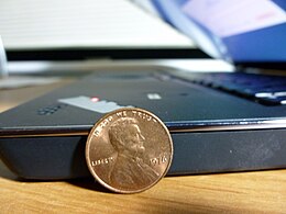 ThinkPad Edge E220s Notebook with penny for size comparison