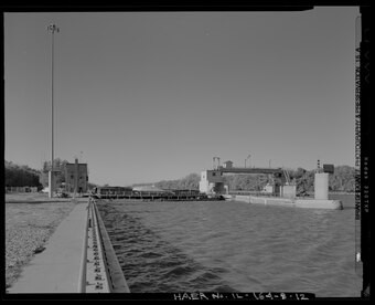 VIEW OF LOCK FROM UPSTREAM. CONTROL HOUSE AT LEFT REAR. TAINTER GATE AT RIGHT REAR. LOOKING SOUTH SOUTHWEST. - Illinois Waterway, Peoria Lock and Dam, 1071 Wesley Road, Creve Coeur, HAER IL-164-B-12.tif