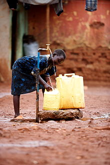 A girl collects clean water from a communal water supply in Kawempe, Uganda. Africa Watsan 7 (10665637964).jpg