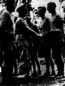 Australian Army officials meet with Australian rules football players before a match at Bougainville in 1945 Army Australian rules football match at Bougainville from Tribune 23 August 1945.png