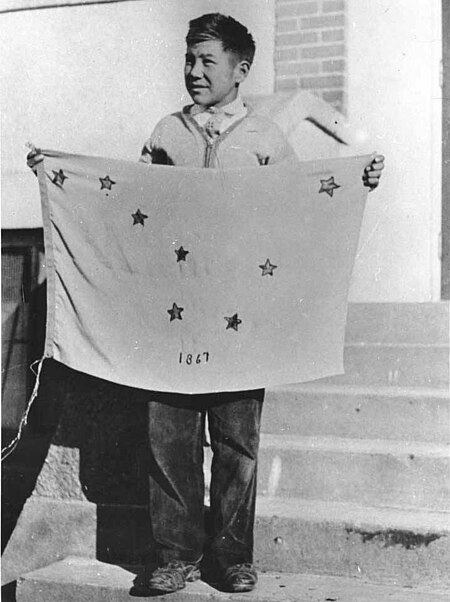 Benny Benson holding the flag of Alaska that he designed.jpg