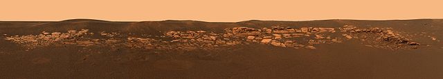 This panorama of Eagle crater shows outcroppings which are thought to have water origins.