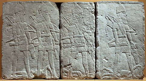 Soldats assyriens tenant des têtes d'ennemis tués au combat, bas-relief du palais de Tell Tayinat, v. 738 av. J.-C. Musée de l'Institut oriental de Chicago.