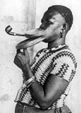 Extended mouthpiece for pipe smoking woman, who is performing in a circus. New York, 1930.