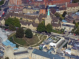 Aerial view of the castle in 2006, showing the castle motte centre left, the square St George's Tower front left and the round Debtors' Tower (constructed in the 18th century, not part of the original building). Behind is Nuffield College with its square tower with a copper-covered fleche. Flight 9.9.06b 011.jpg