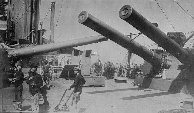 The guns of 'P' and 'Q' turrets trained across the deck