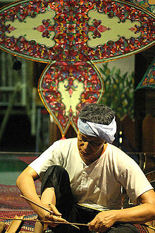 Making of the traditional wau Jala Budi. The bamboo frame is covered with plain paper and then decorated with multiple layers of shaped paper and foil. Malaysiakite.jpg
