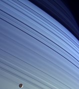Silueta de Mimas, contrastando con las latitudes más septentrionales de Saturno.
