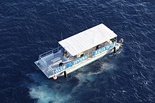 Another arrangement of a flush decked rigid hulled dive boat suitable for flat water and sunshine, with side mounted boarding ladders and centreline seats. Oasis Divers Aqua Tours (8646345440).jpg