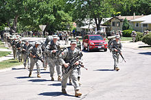 National Guard officer candidates take part in a tactical road march through a west Rapid City neighborhood.