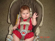 Child held in a car seat by a five-point harness Safeseat.jpg