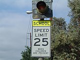 A school zone sign in the United States. When the light flashes, the set speed limit (in this case, 25 mph (40 km/h)) is active.