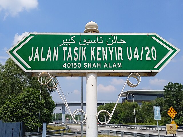 Street name signs in Shah Alam, Malaysia include both Jawi and Latin script.