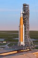 Artist's rendering of the Space Launch System Block 1 sitting on LC-39B with the Orion spacecraft at sunrise.