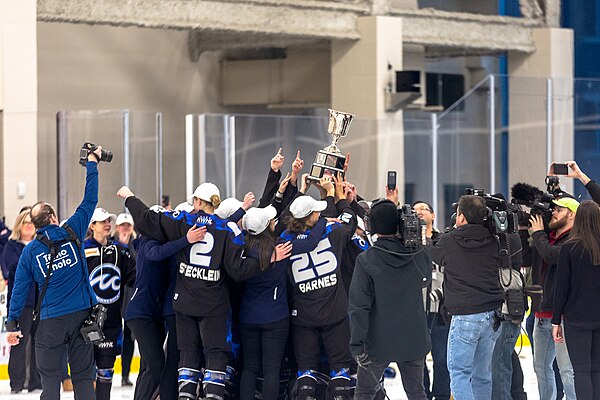 The Minnesota Whitecaps team holds up the Isobel Cup, celebrating the NWHL playoff championship in 2019.