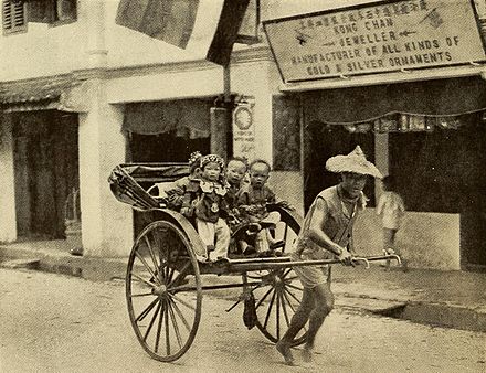 Children in a rickshaw pulled by a Chinese coolie in Kuching around 1919