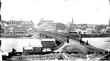 On May 4, 1873, the heaviest crowds gathered on the sidewalk, near the location of the horse and buggy in this photo. The Truesdell Bridge at Dixon, c. 1869.jpg