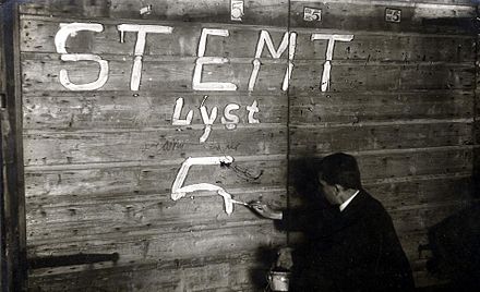 A man writing political slogans on a wooden fence in Amsterdam Verkiezingen. Een man verft de letters 'Stemt lyst 5' op een houten schutting. (De socialisten).(Amsterdam),1918. - SFA022823005.jpg