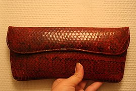 A vintage clutch with a fold-over closure, made of red snakeskin