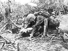 A wounded Marine receives a drink from a Navy corpsman. Wounded Marine on Peleliu.jpg