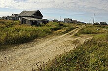 A dirt road leading to a dilapidated Russian village is depicted.