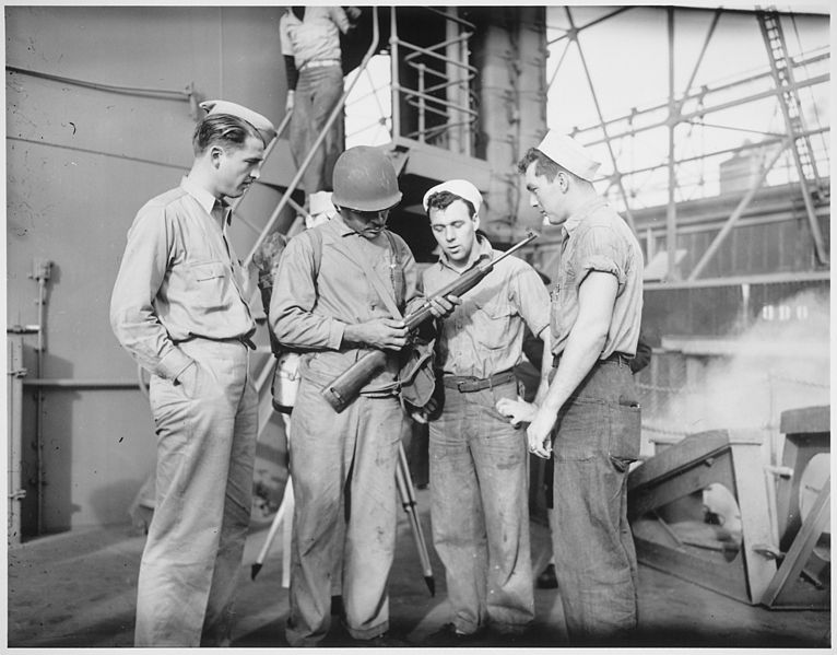 File:"Aboard a Coast Guard-manned transport..., a Negro Marine, Robert Stockman, goes over his carbine with Coast Guardsmen." - NARA - 513195.jpg