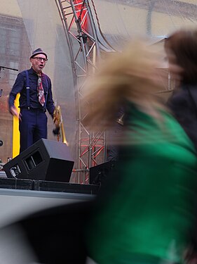 Musician on stage. Audience dancing off stage.