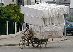 Tricycle lourdement chargé dans une rue de Shanghai (Chine).