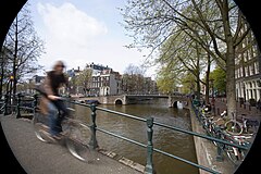 Street scene. A bicycle crossing a bridge in an Amsterdam Channel. The Netherlands