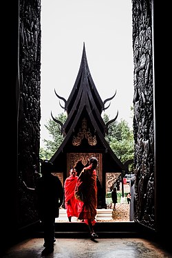 Buddhist monks entering the Black Temple in Chiang Rai, Thailand