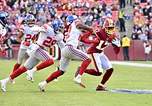 Baker (center) in a 2019 game against the Washington Redskins Deone Bucannon.jpg