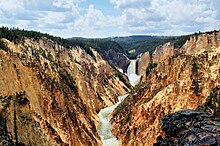 Canyon with yellow and tan rock with river and water fall