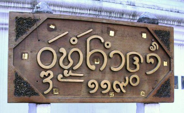 Nameboard of a Buddhist temple in Chiang Mai written with Tai Tham script: Wat Mokhamtuang (and street number 119 in Thai)