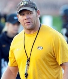 Barry Odom in a t-shirt and hat.