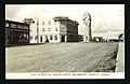 A view looking north of Main Street showing automobiles and a clock tower as well as some businesses along the street, taken in the 1930s.