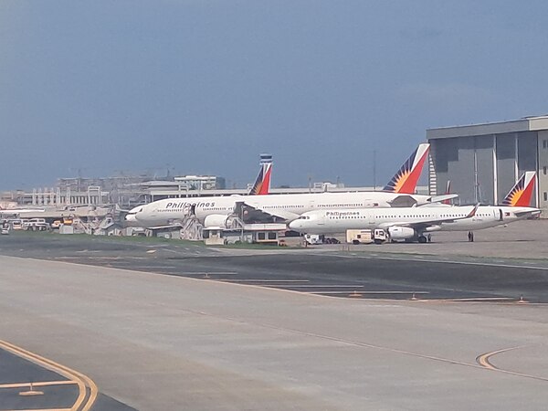 Aircraft of Philippine Airlines parked next to the maintenance hangars of Lufthansa Technik Philippines