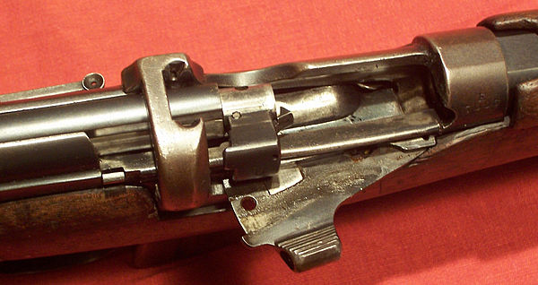 Close-up of the action on an SMLE Mk III rifle, showing the bolt head, magazine cut off, and charger clip guide.