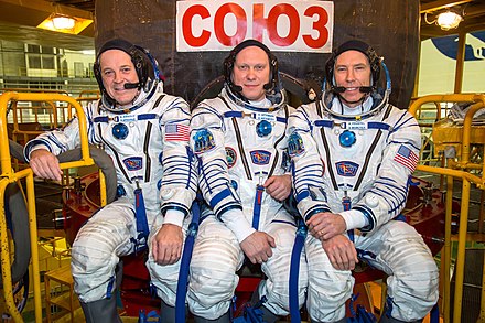 Soyuz MS-08 crew members in front of their spacecraft.jpg