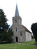 Una piccola chiesa in pietra con una guglia davanti