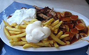 A "Taxi Teller" is a plate of fries served with currywurst, shashlik sauce, mayonnaise, gyros meat, and tzatsiki.