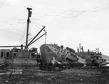 Nestor driven aground at Buckner Bay, Okinawa, by wind and heavy seas during Typhoon "Louise", 9 October 1945. The aftermath of the typhoon found this jumble of ships with Nestor's bow (center of photo) through the stern of Ocelot. Note the YTB alongside. USS Ocelot (IX-110), USS Nestor (ARB-6) and APL-14 aground in Buckner Bay, Okinawa, in November 1945 (NH 105655).jpg