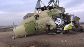 Drapeaux des Forces démocratiques syriennes et de Jaysh al-Thuwar sur l'épave d'un hélicoptère de l'armée de l'air syrienne dans l'aéroport de Menagh, le 12 février 2016.